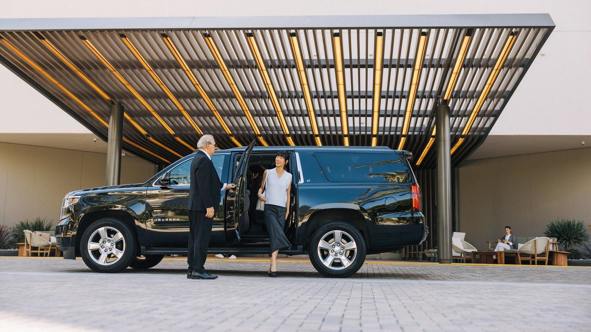 Black executive SUV waiting at a hotel entrance for a chauffeur journey