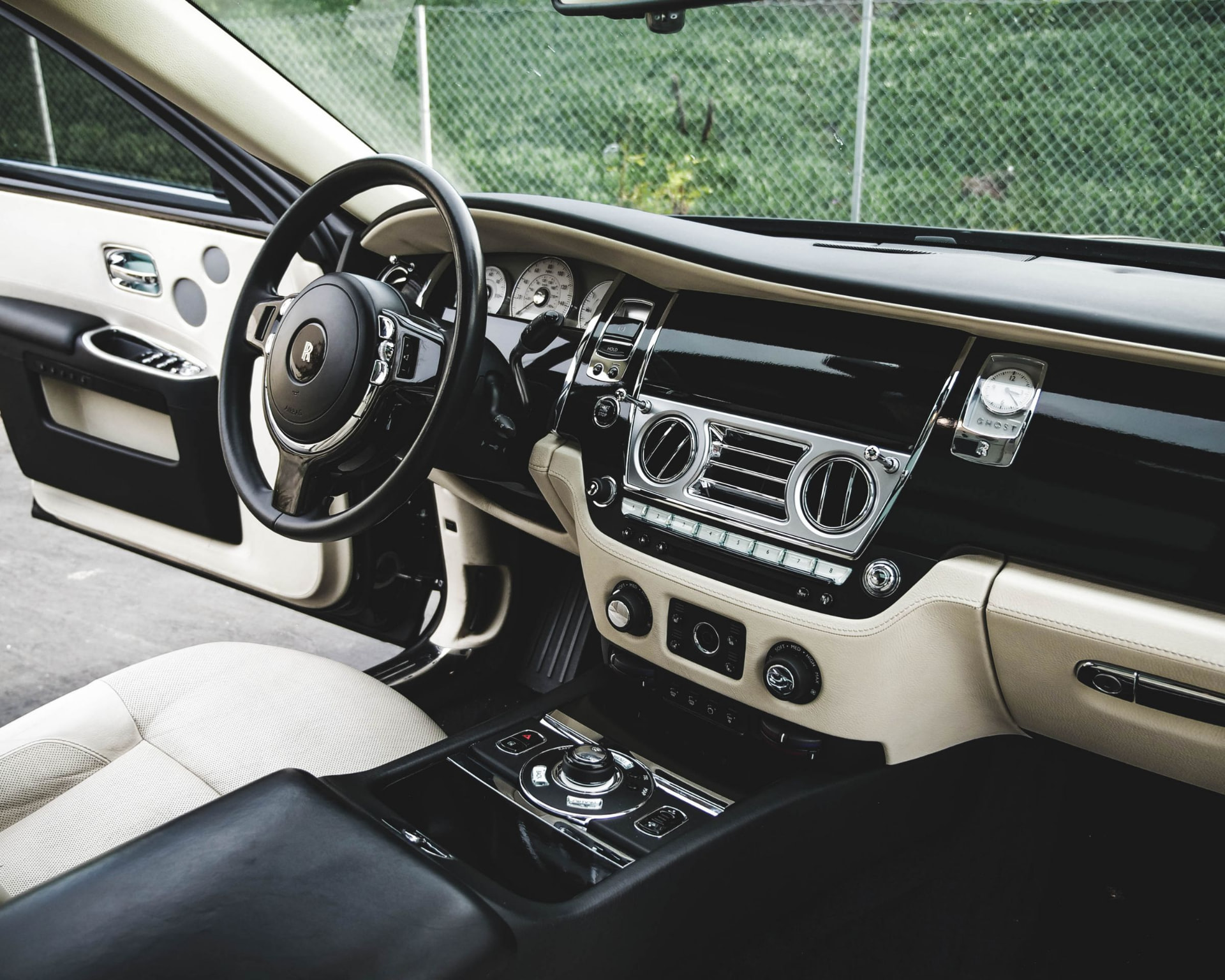 Luxury car cabin with cream leather seats, polished black trim and chrome detailing